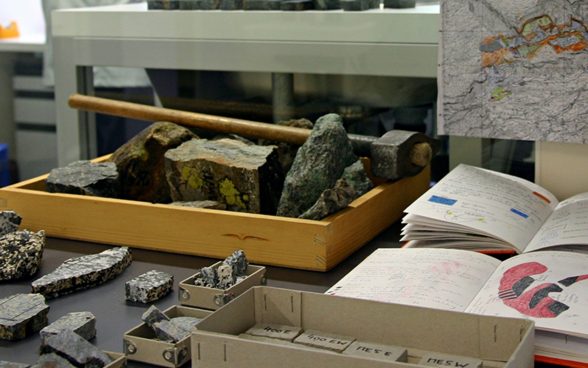 Hammer, field book and hand specimens of rock